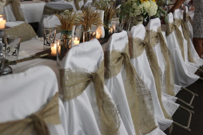 wedding banquet chairs with white covers and gold ribbons