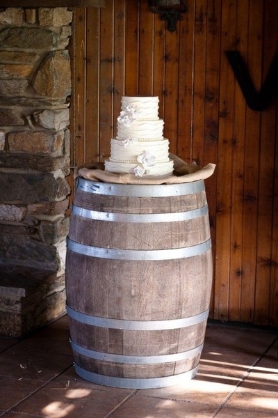 wedding cake on the top of a rustic wine barrel